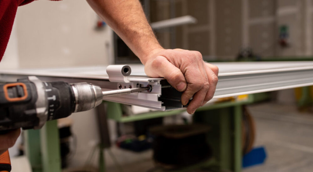 A male with a red shirt making a window with industrial tools